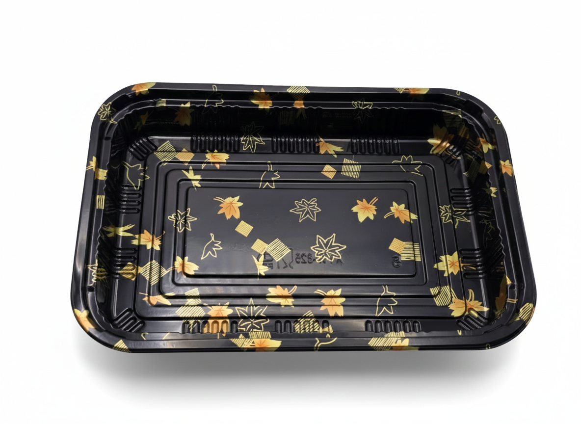 Black plastic tray with gold floral patterns on a white background
